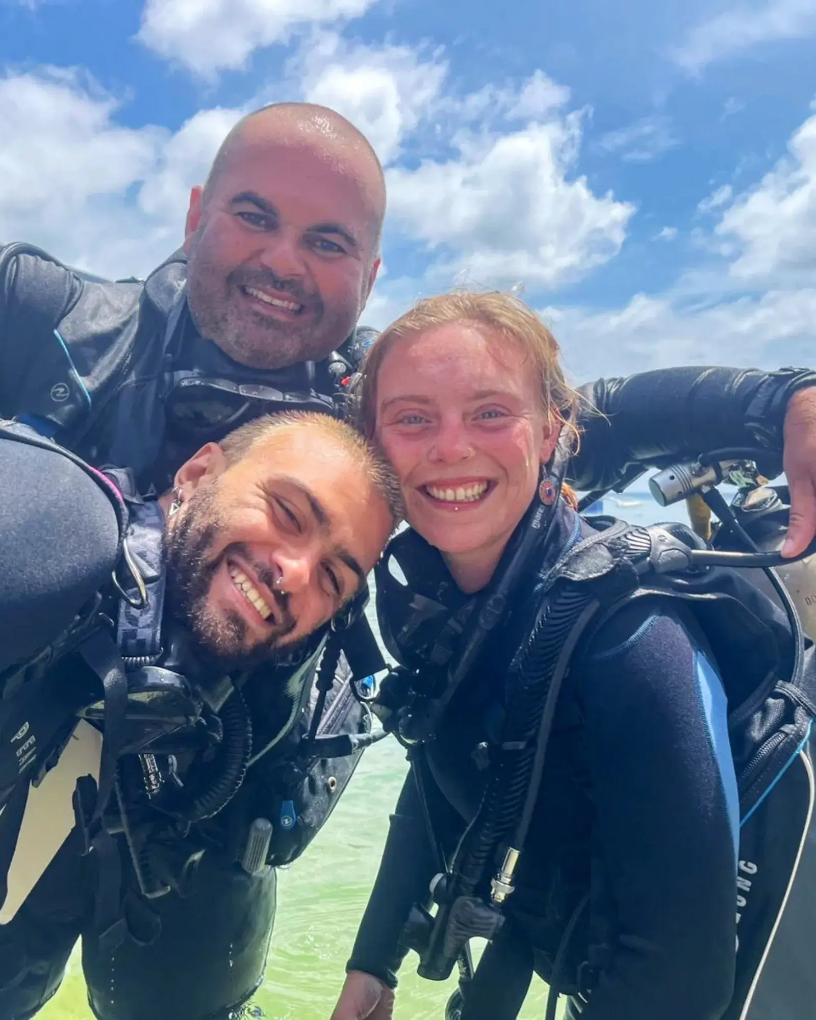 Beginner divers celebrating their first dive in Siquijor, Philippines, with their instructor.